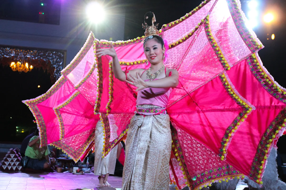 A dancer in an elaborate pink Lanna costume at a Khantoke show