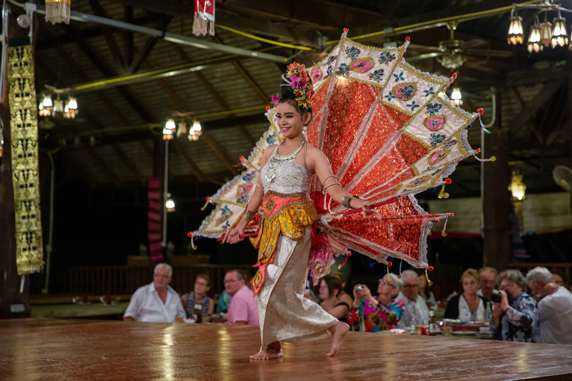 A Lanna dancer performing with an ornate fon lep-style costume at a Khantoke show in Chiang Mai